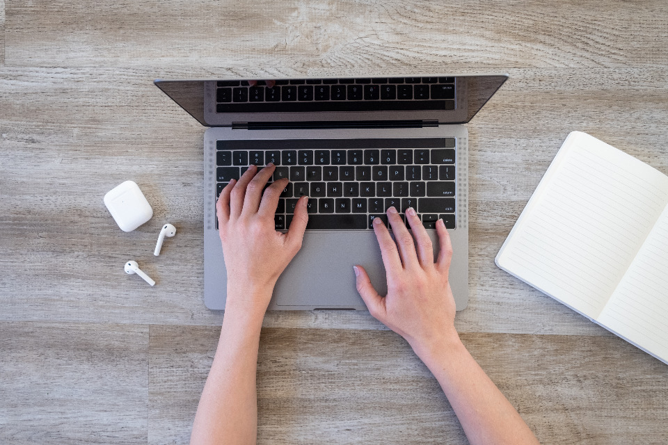 Hands typing on a laptop during an online consultation